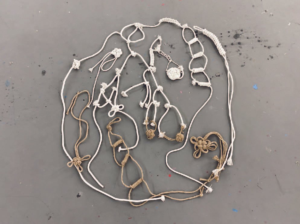 Circular composition of cotton and jute knots linked into a closed loop.